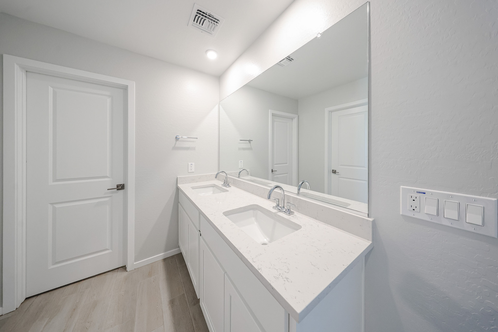 A bathroom with a large mirror.