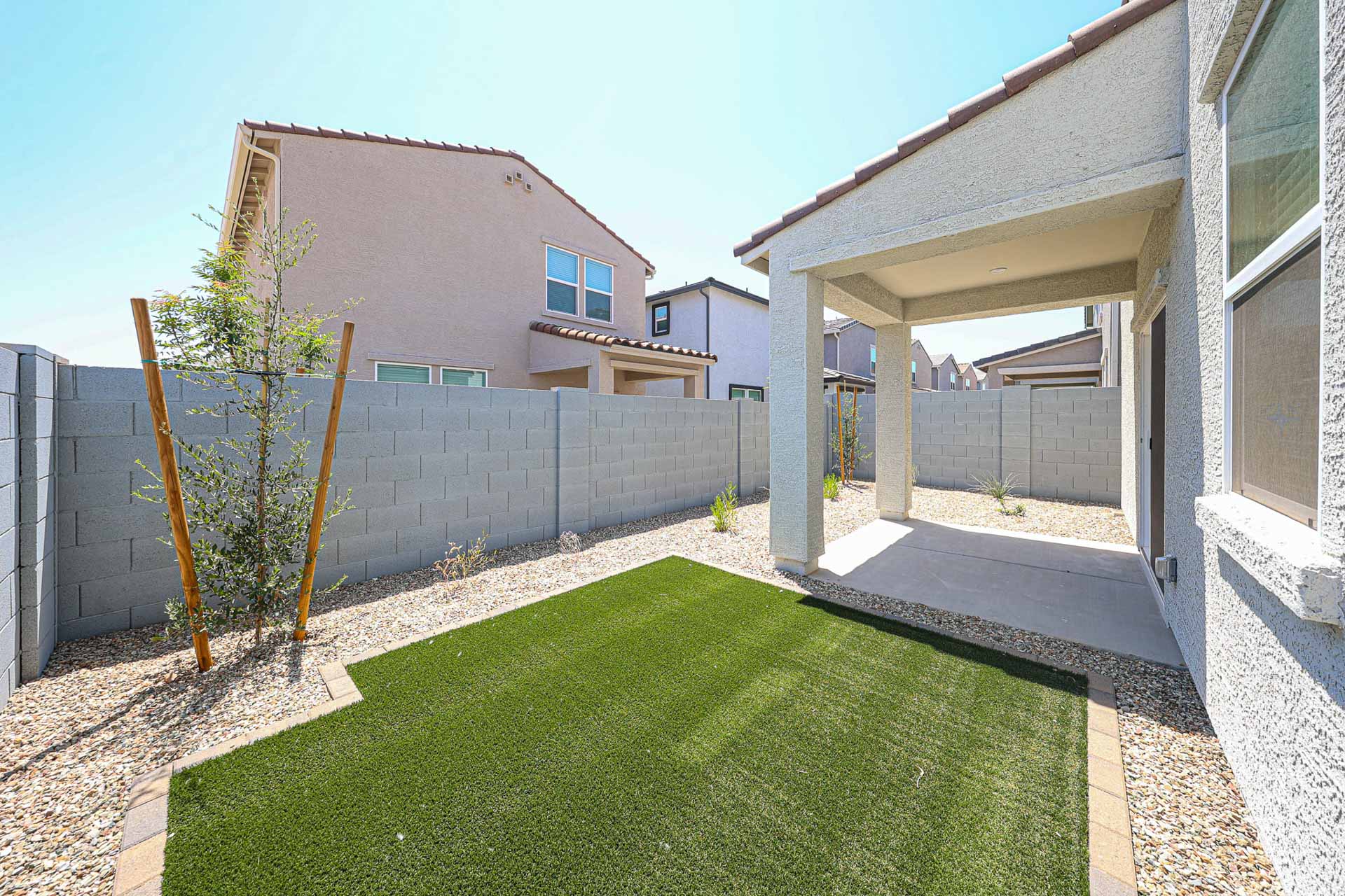 A backyard with a fence and a tree.