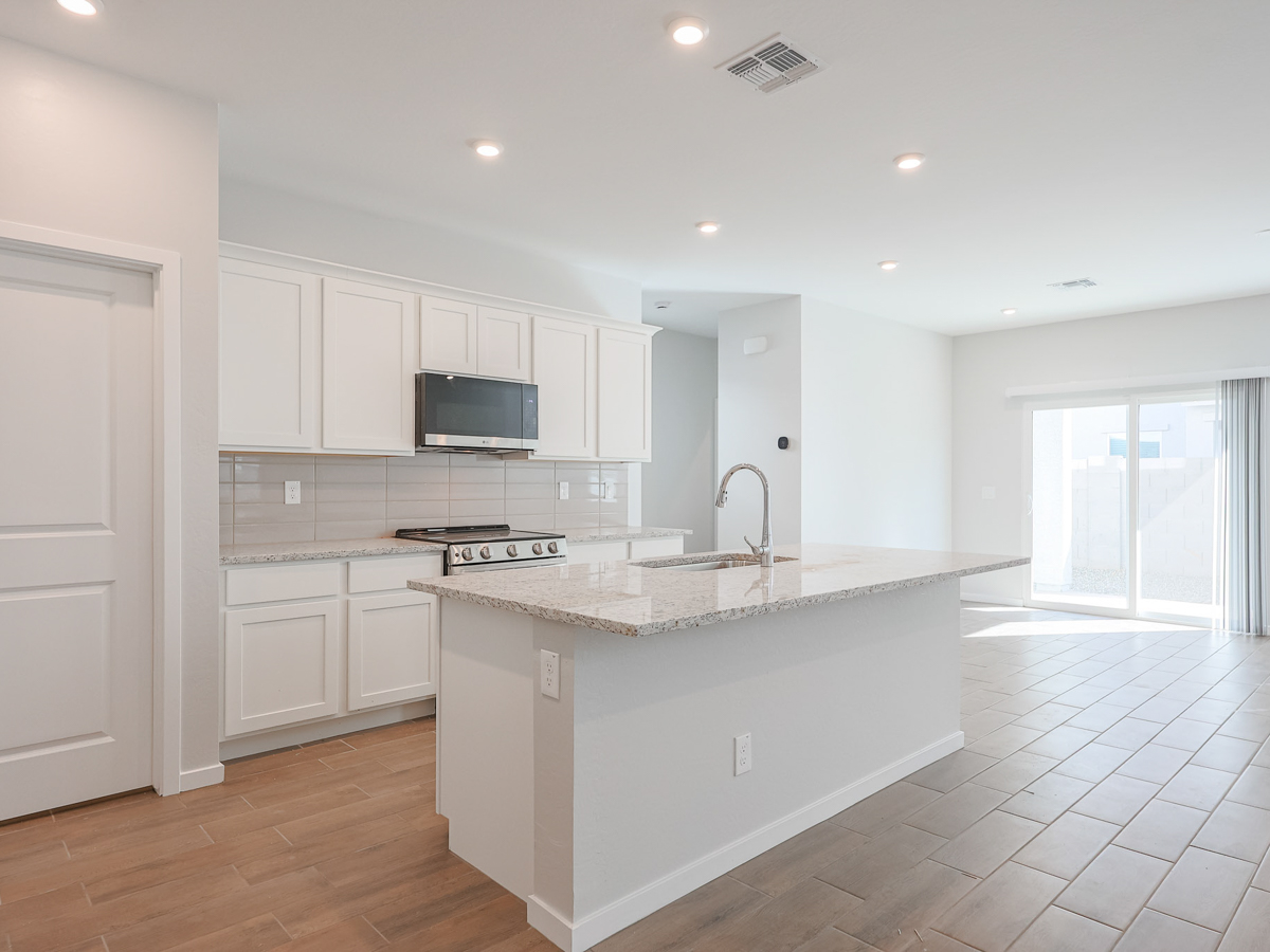A kitchen with white cabinets.