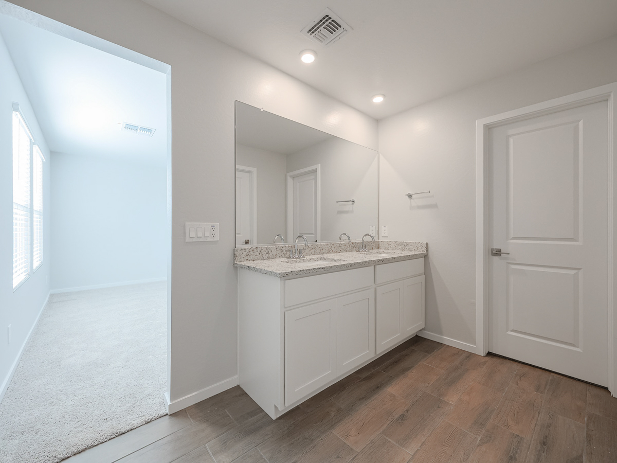 A bathroom with white cabinets.
