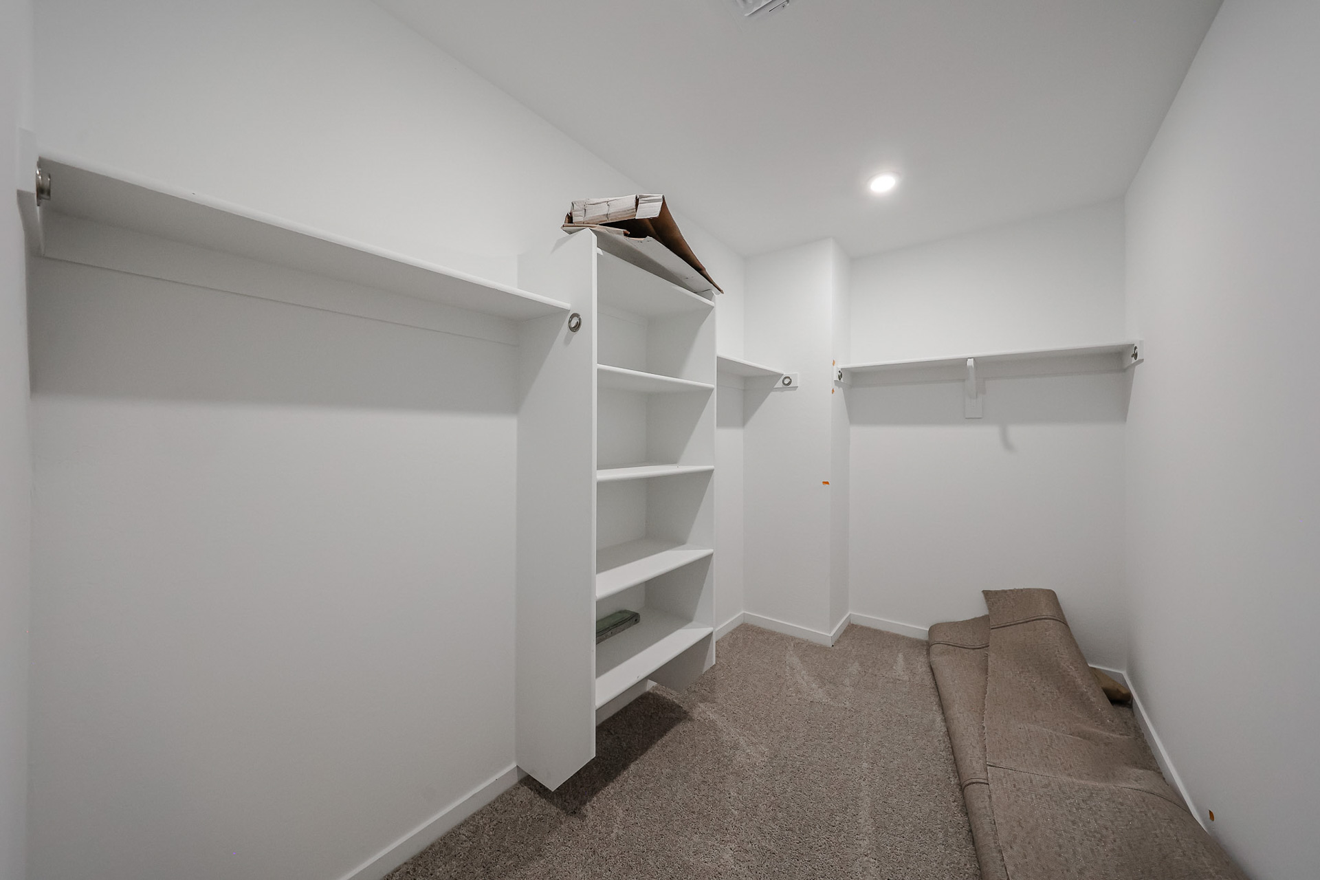 A room with white shelves.