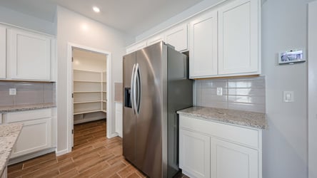 A kitchen with white cabinets.