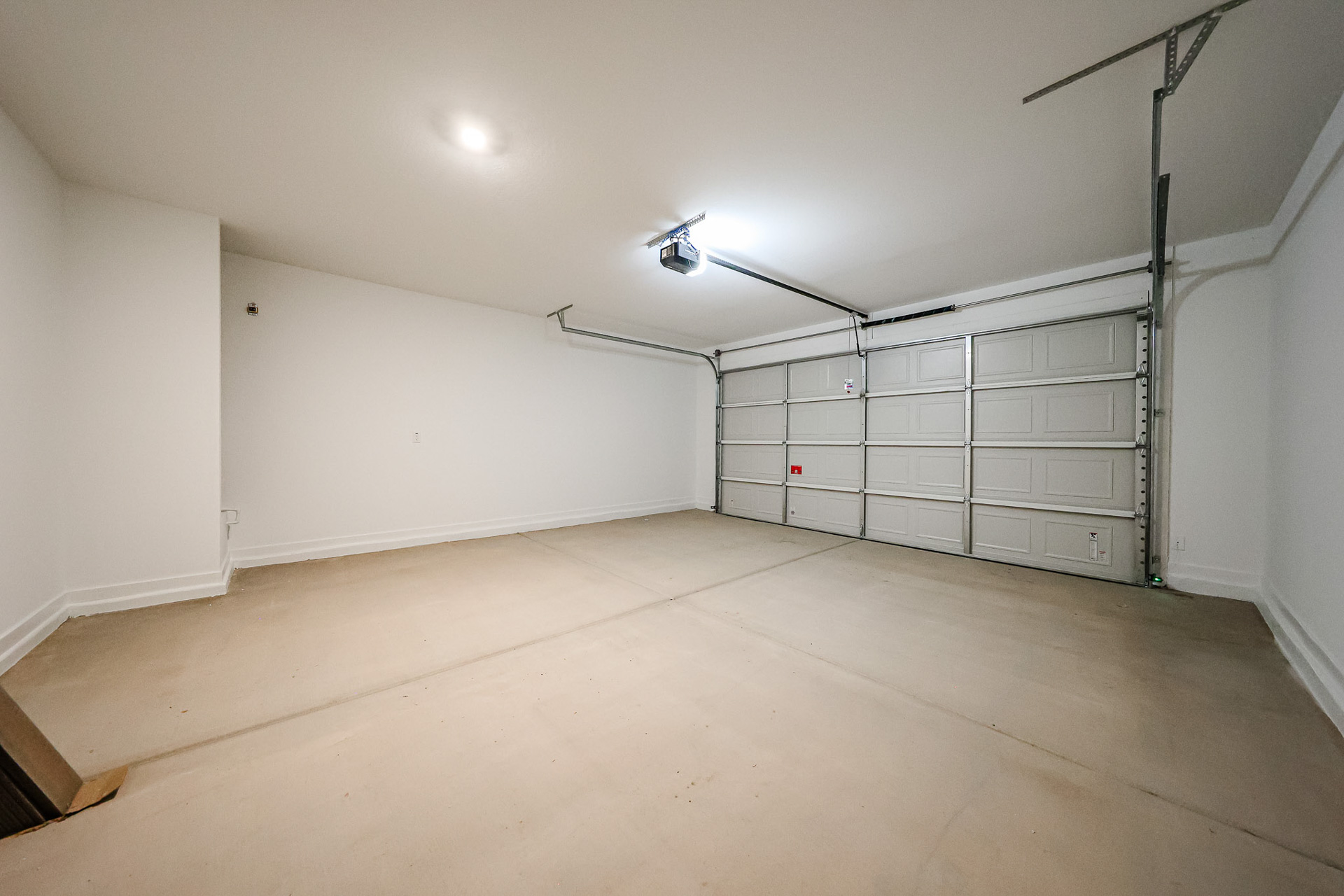 A room with a white wall and a metal gate.