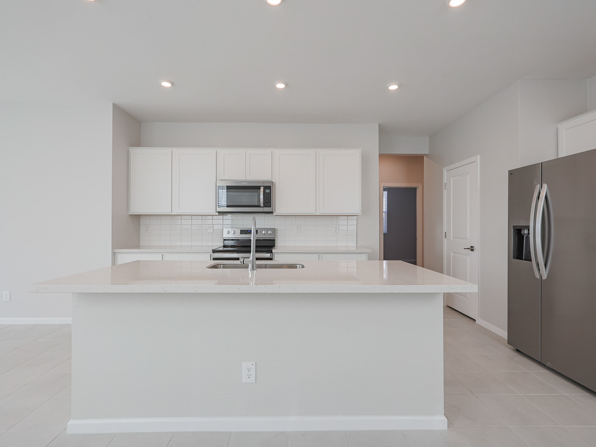 A kitchen with white cabinets.