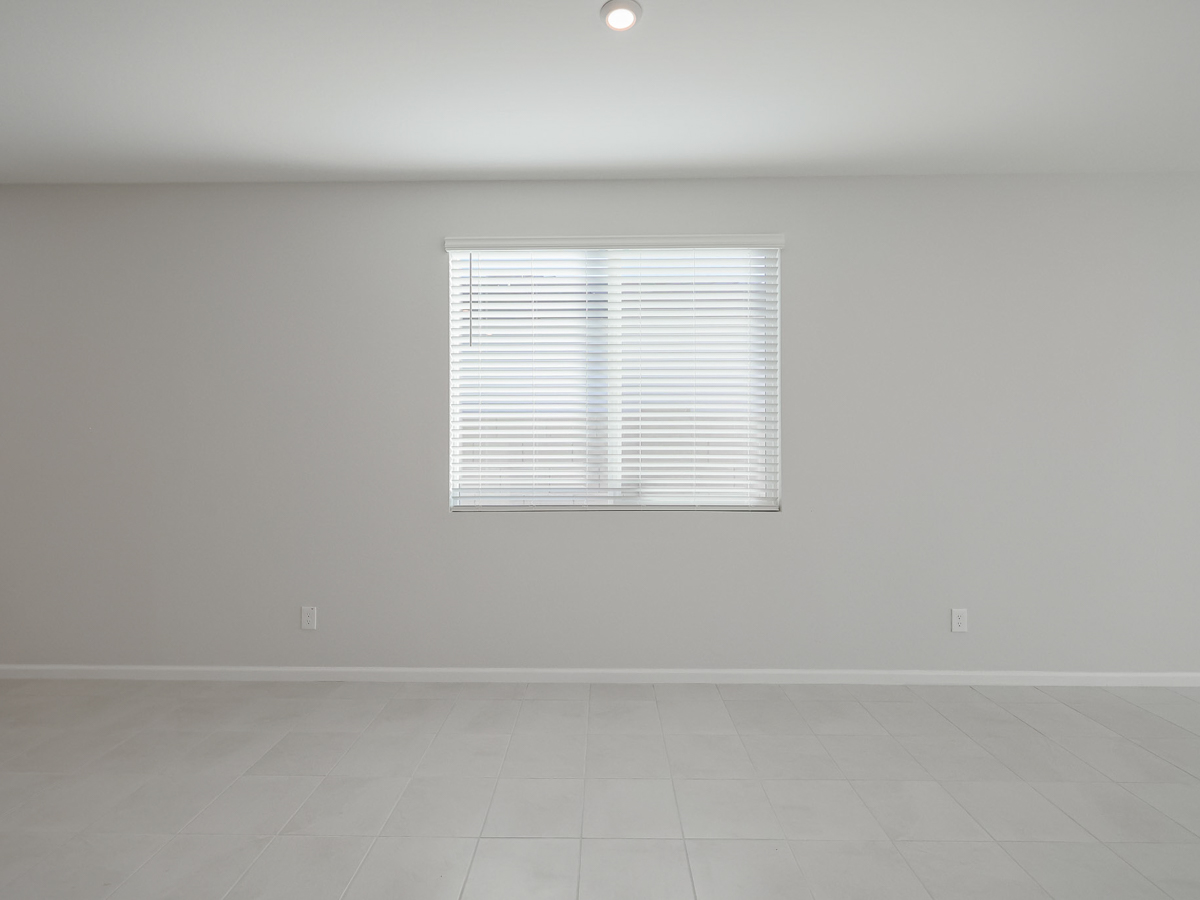 A room with a window and a tile floor.