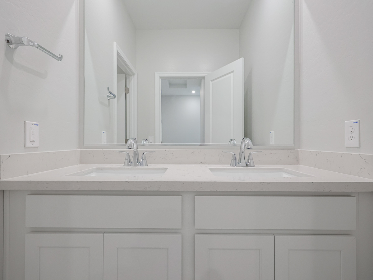 A bathroom with white cabinets.
