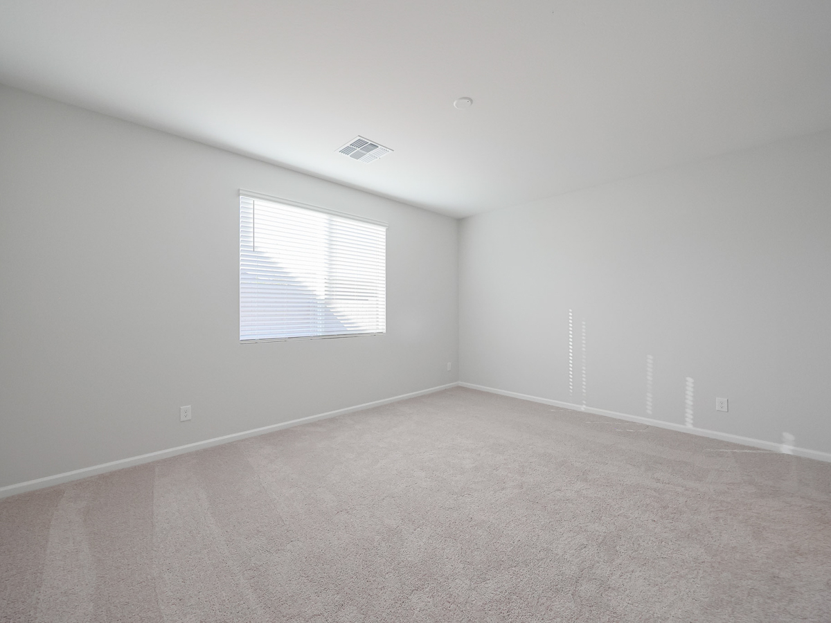 A room with a window and carpet.