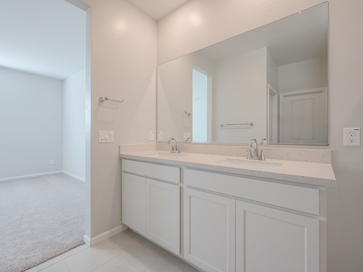 A bathroom with white cabinets.
