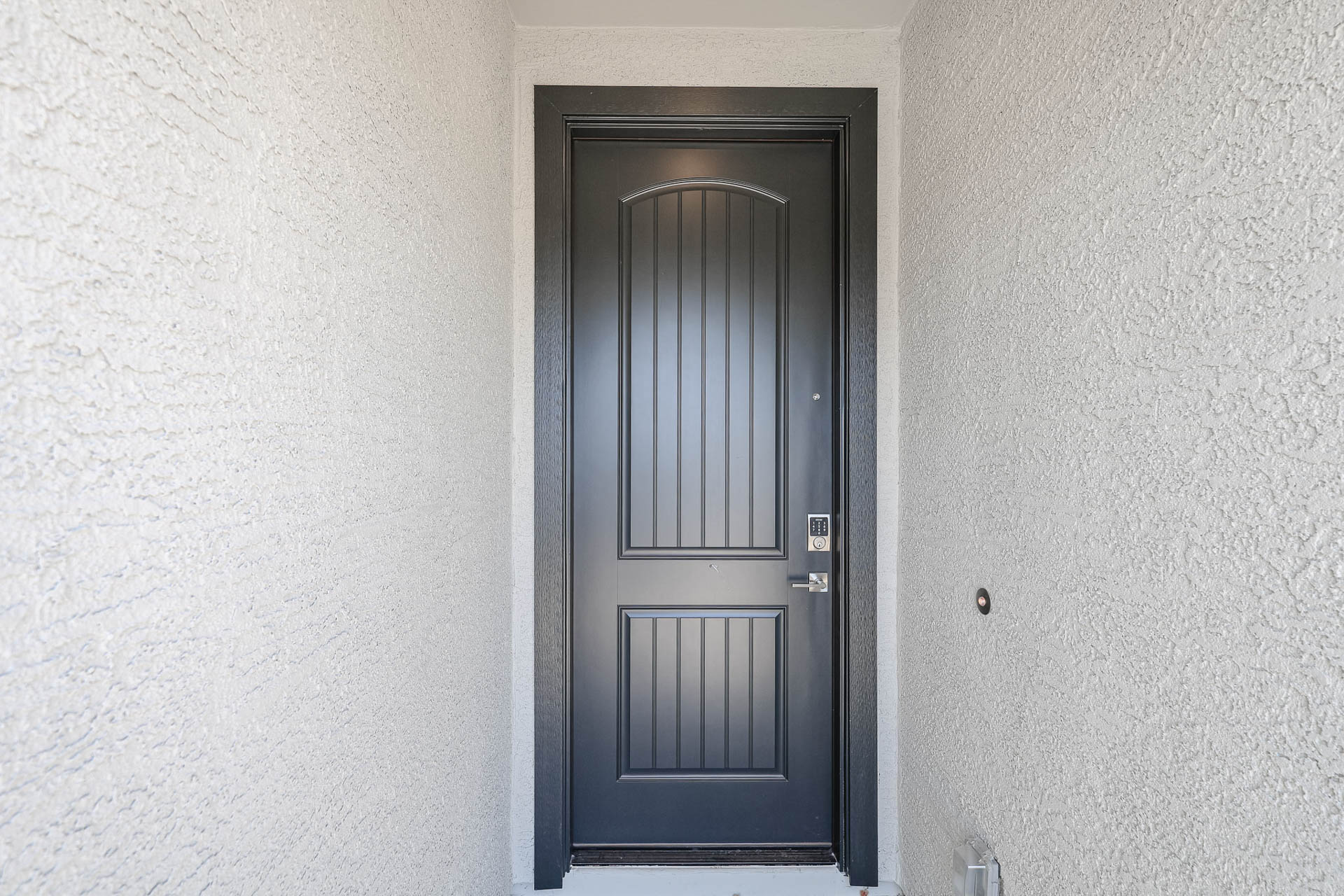 A black door in a white room.