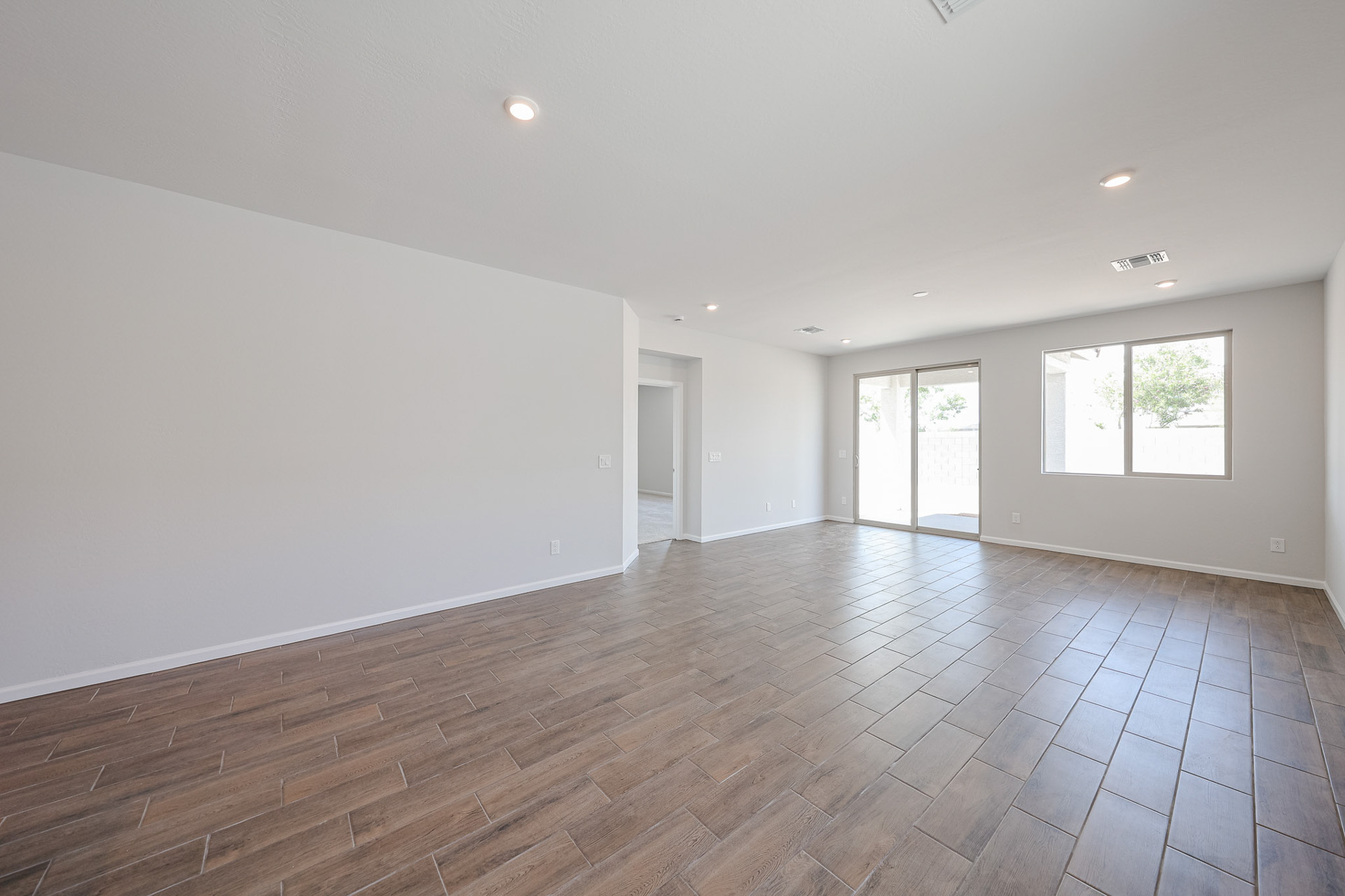 A room with a wood floor and windows.