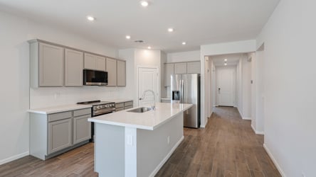 A kitchen with white cabinets.