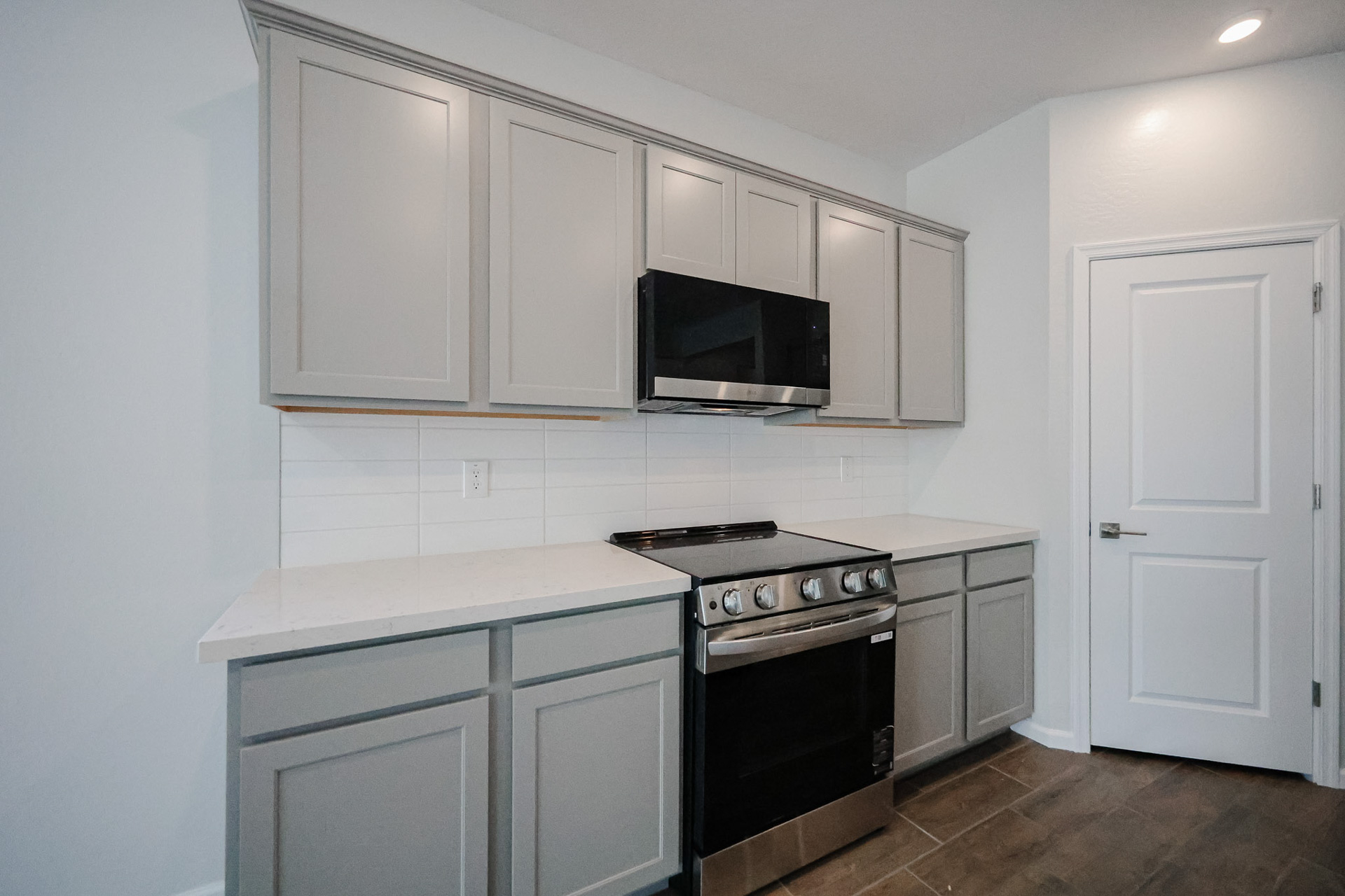 A kitchen with white cabinets.
