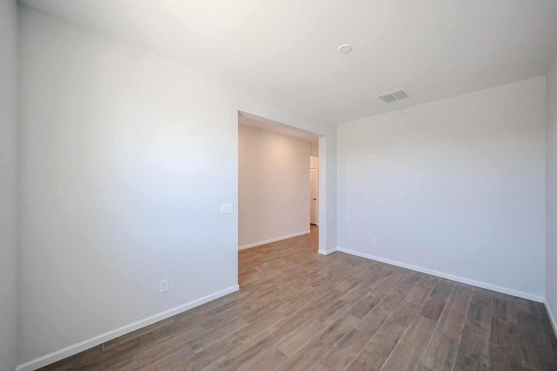 A hallway with a wood floor.