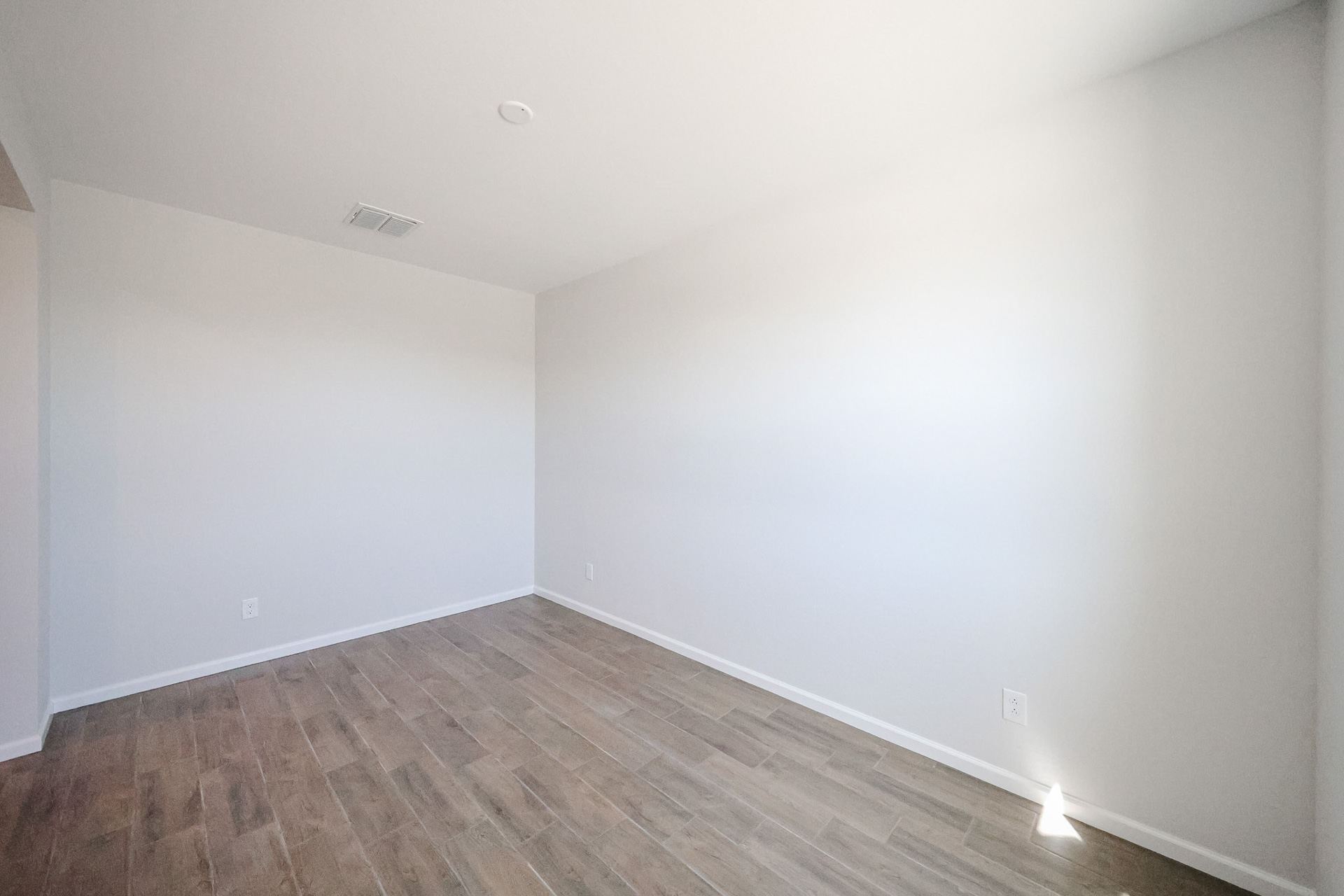 A room with a wood floor and white walls.