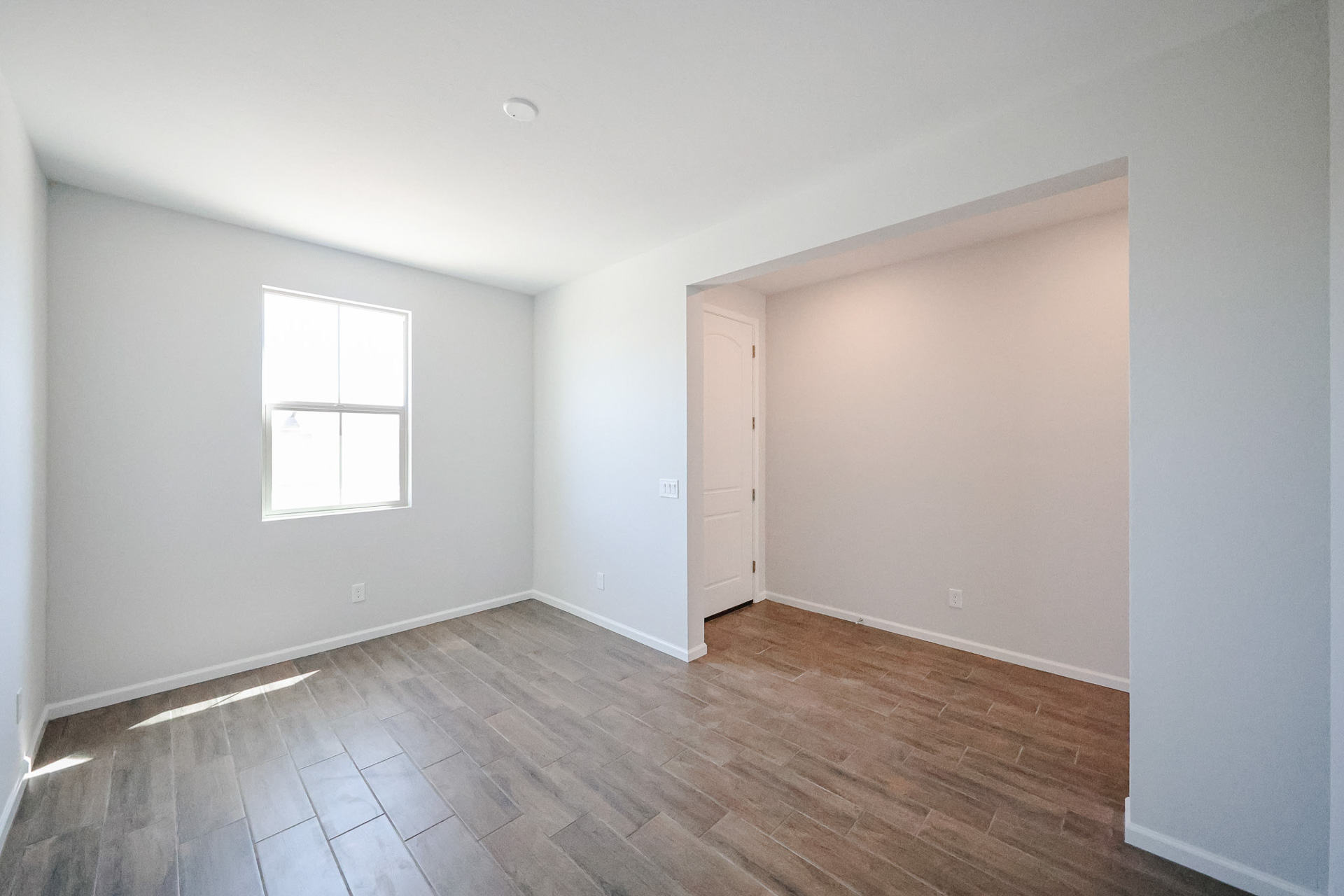 A room with a wood floor and a white door.