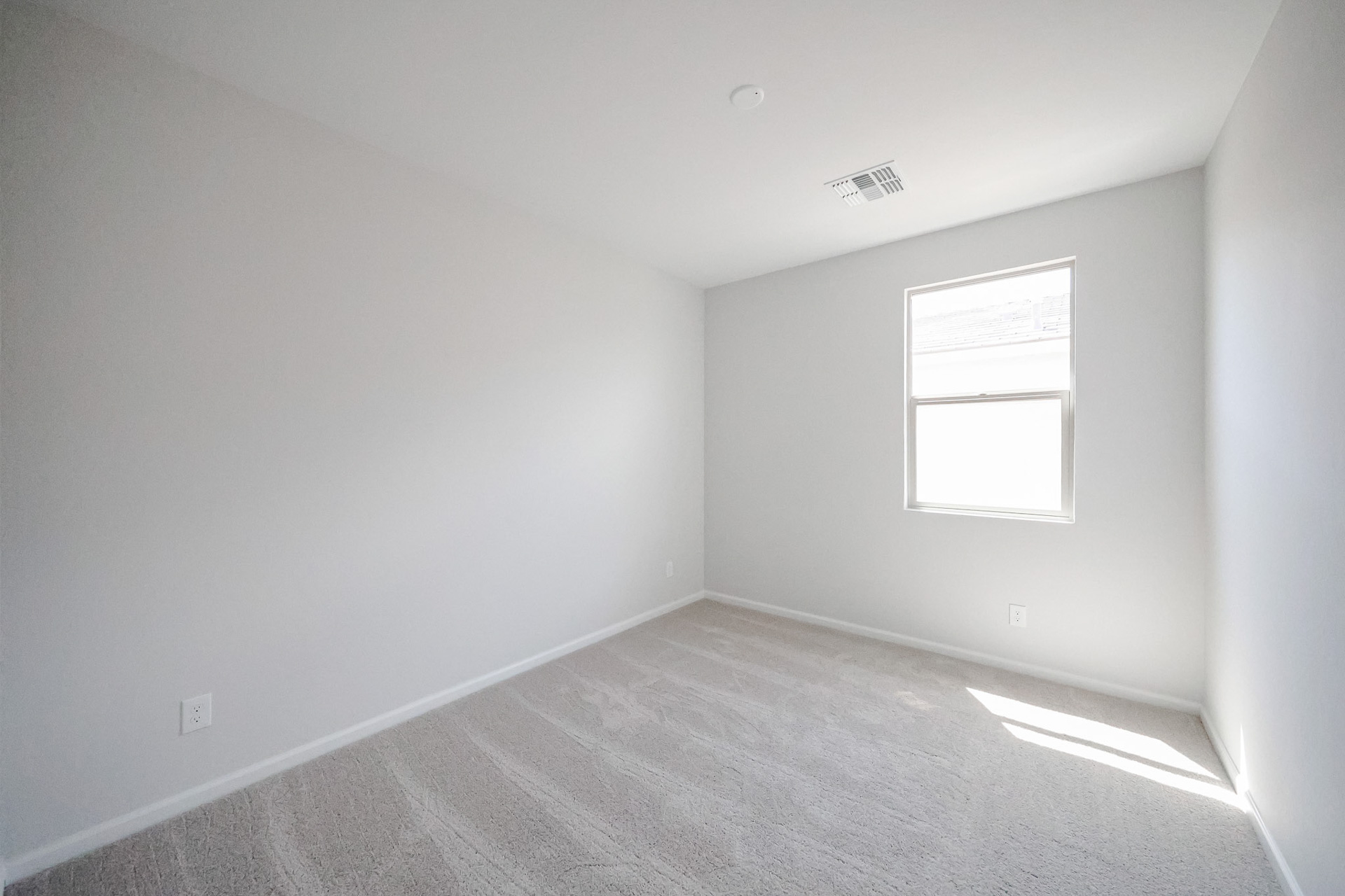 A room with a window and a carpet.