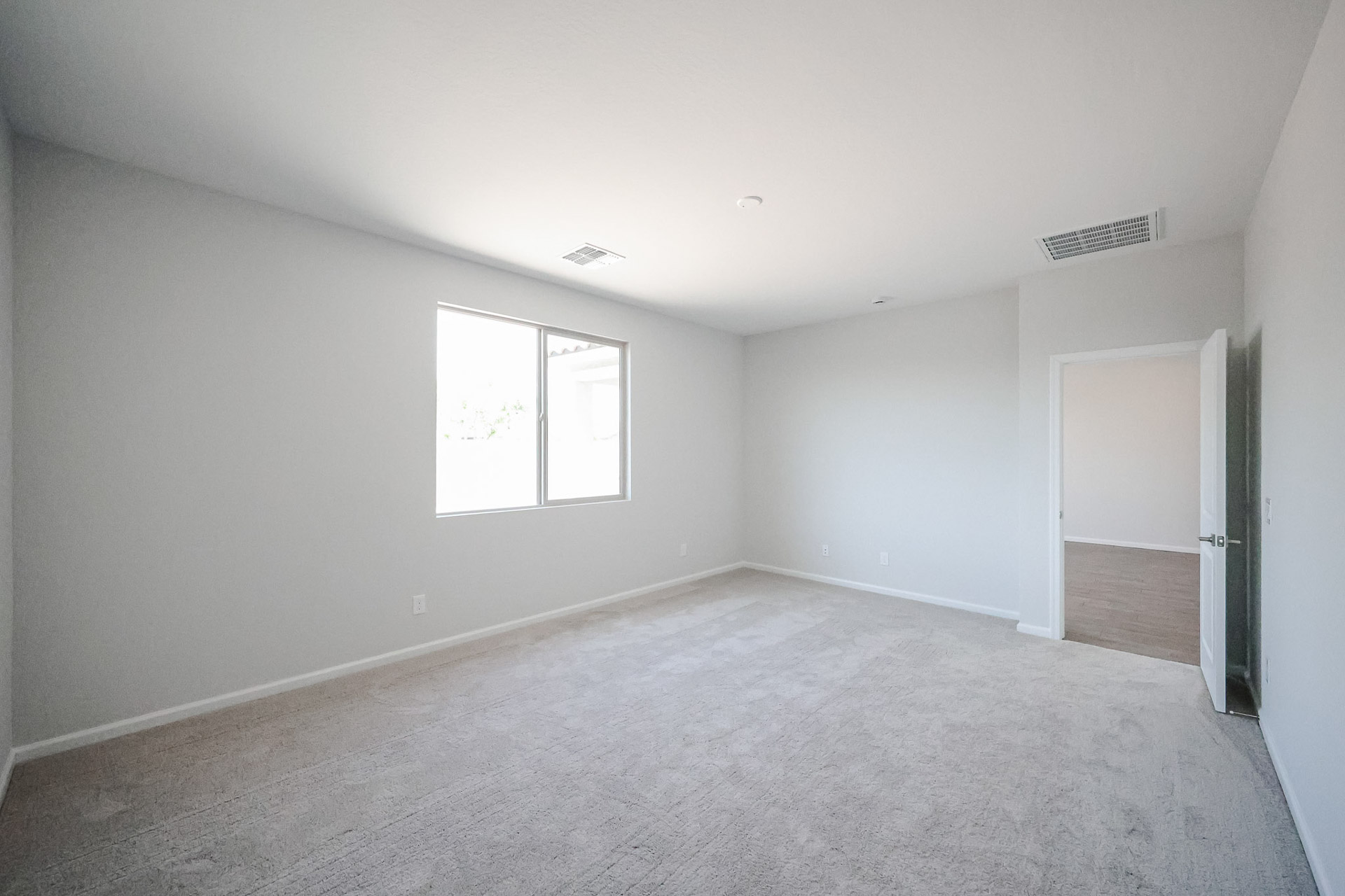 A room with a carpet and a door.