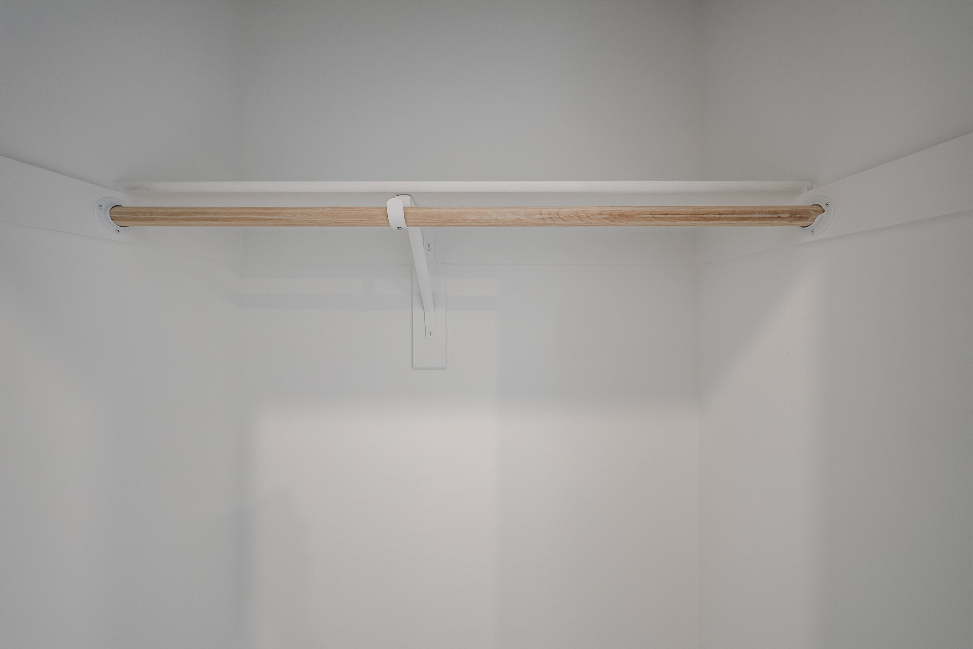 A wooden cross on a white wall.