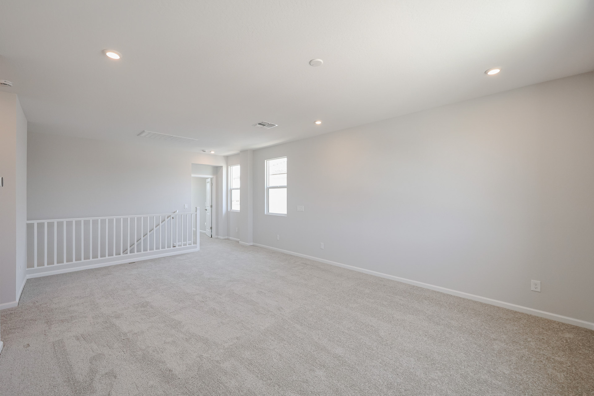 A room with white walls and a railing.