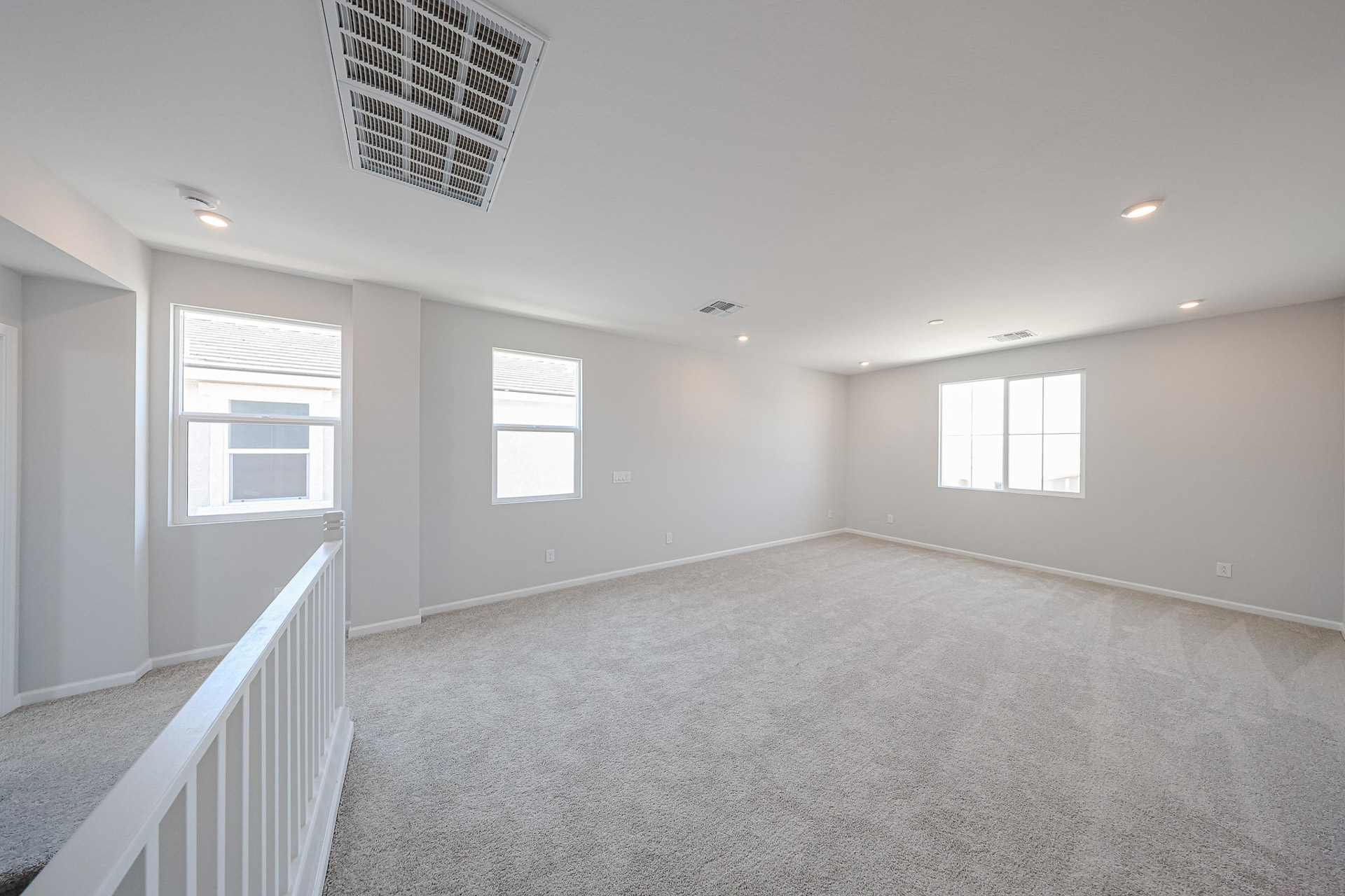 A room with a carpet and windows.
