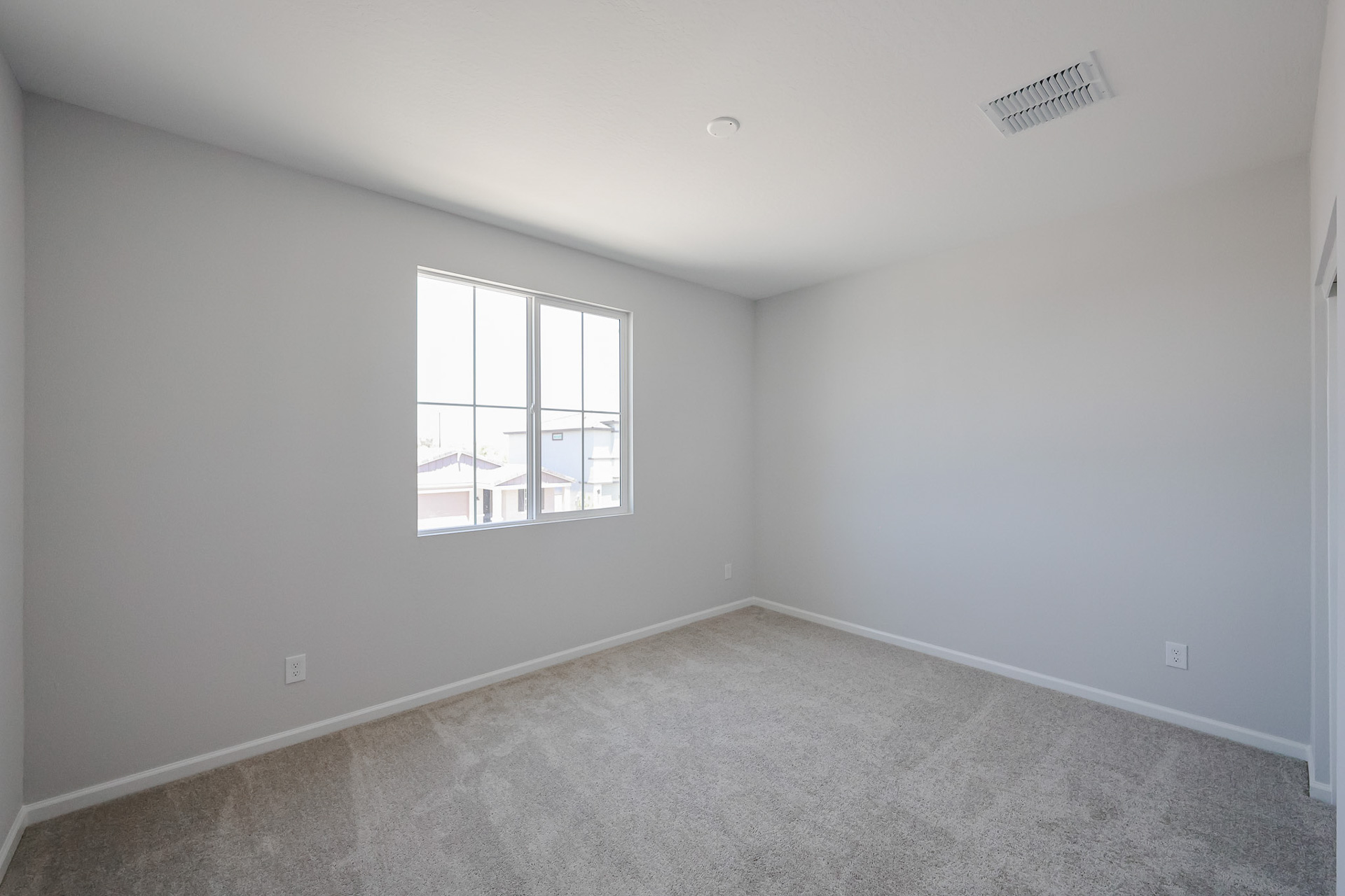 A room with a window and carpet.