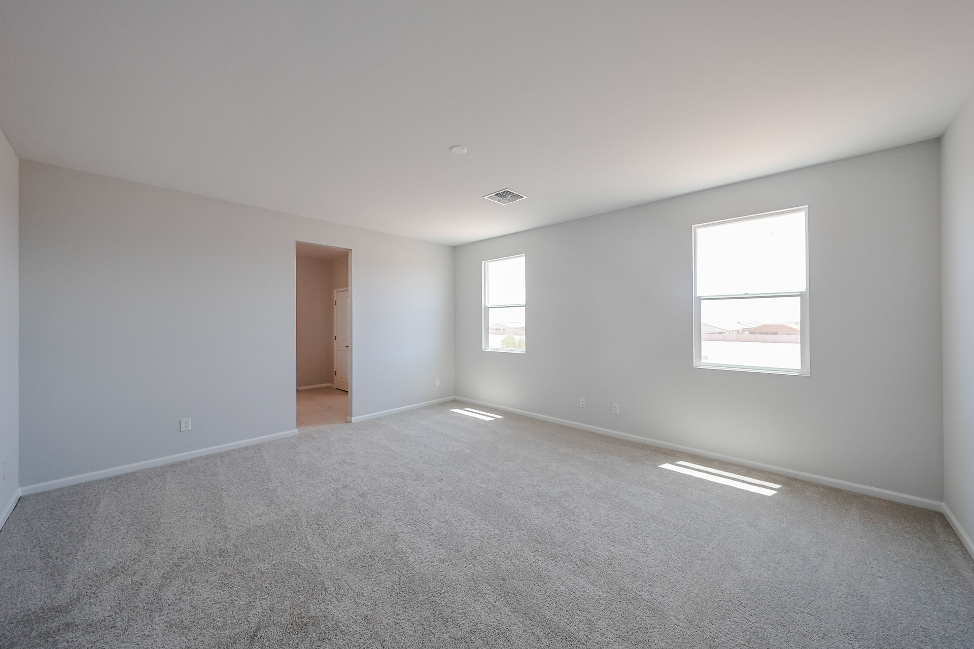 A room with a carpet and windows.