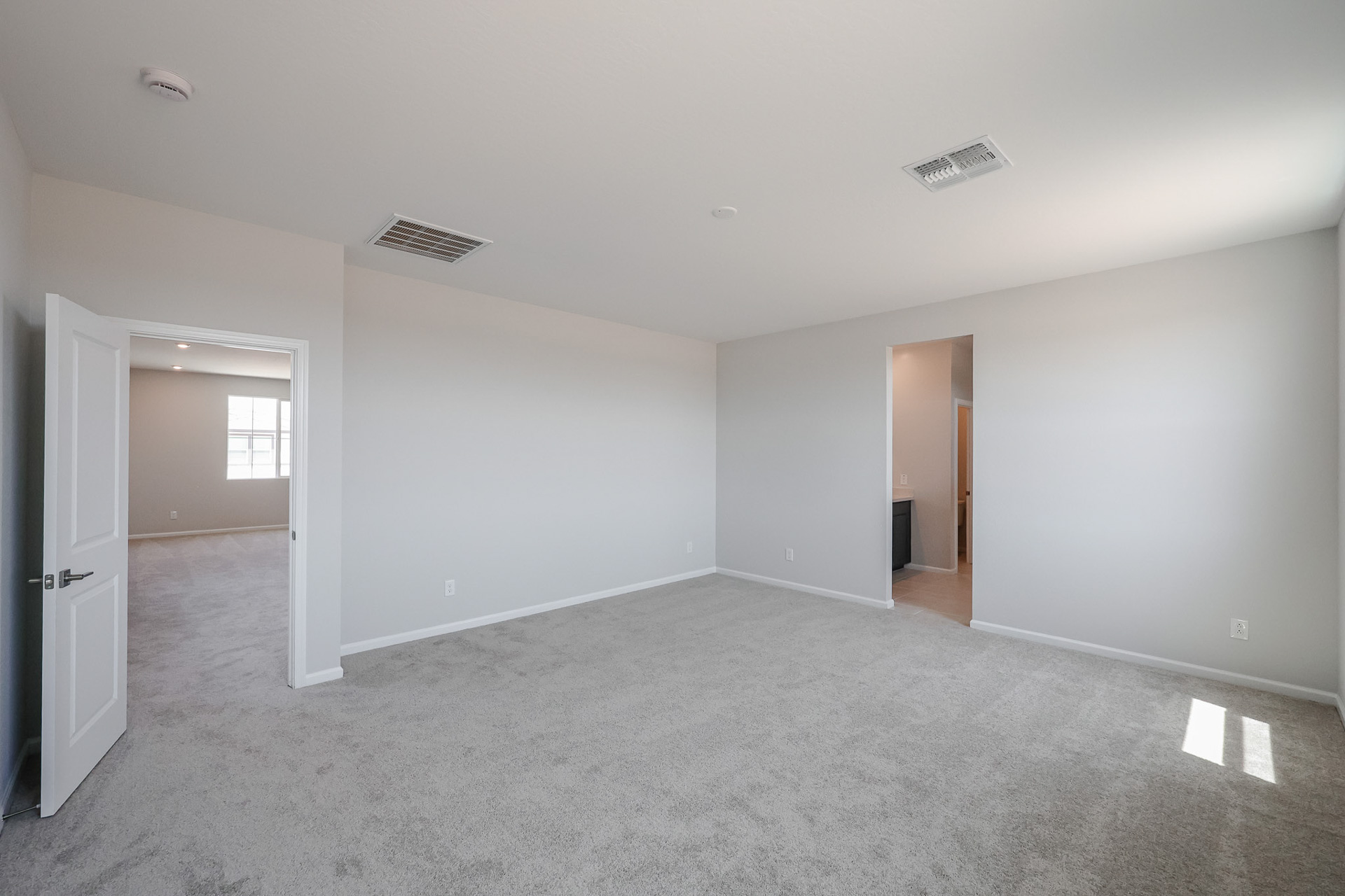 A room with a carpet and a door.