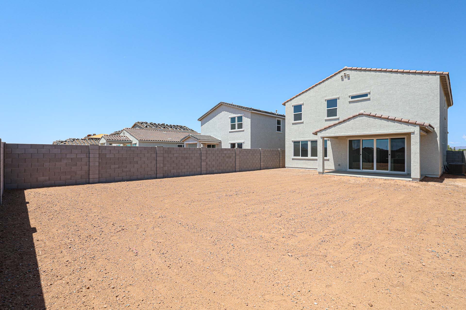 A dirt field with buildings in the background.
