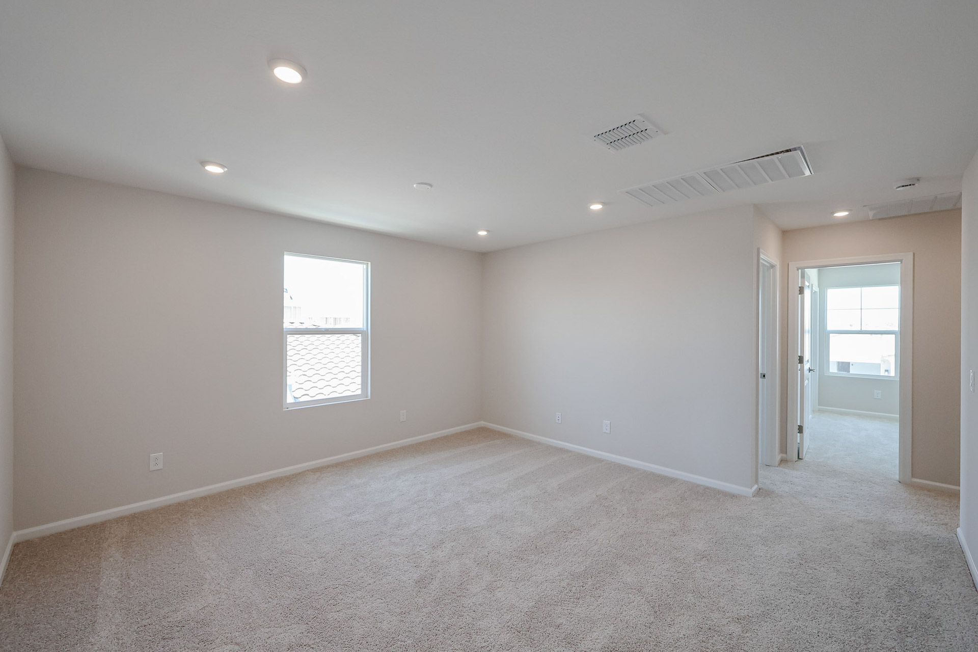A room with a carpet and windows.