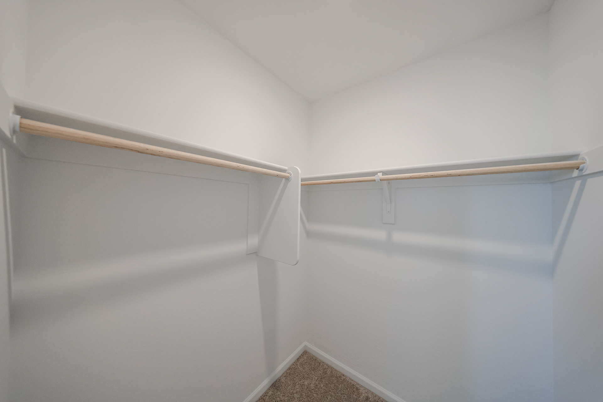 A white wall with a metal bar.