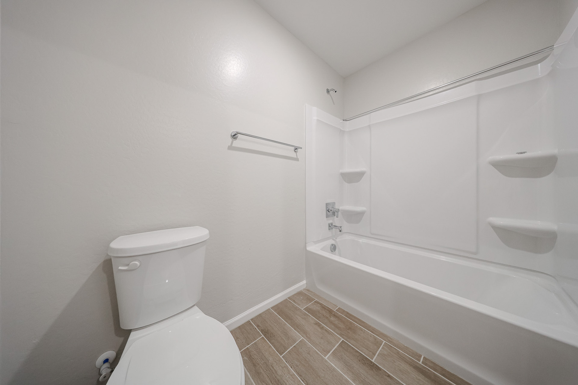 A bathroom with a toilet and bathtub.