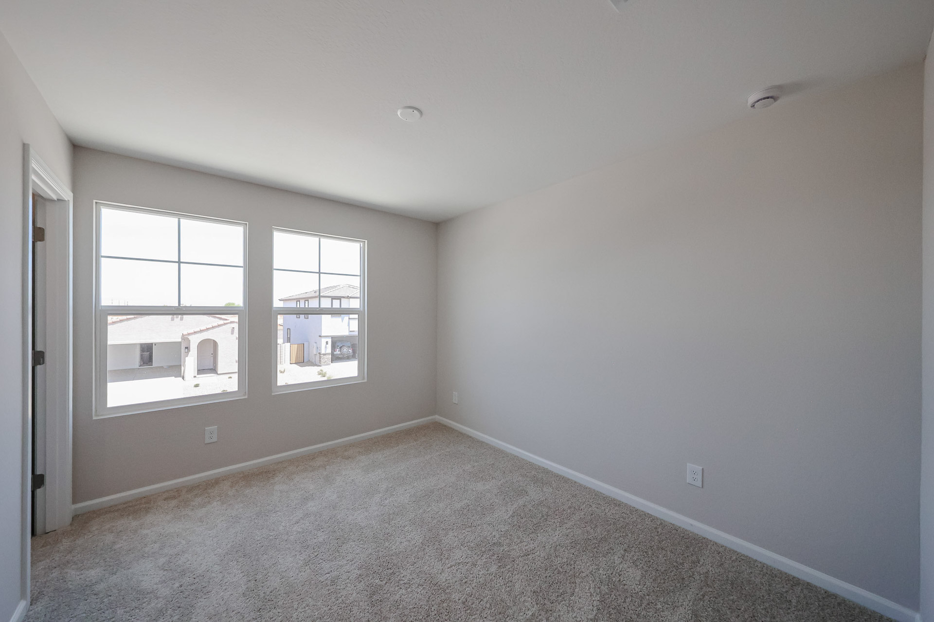 A room with a carpet and windows.