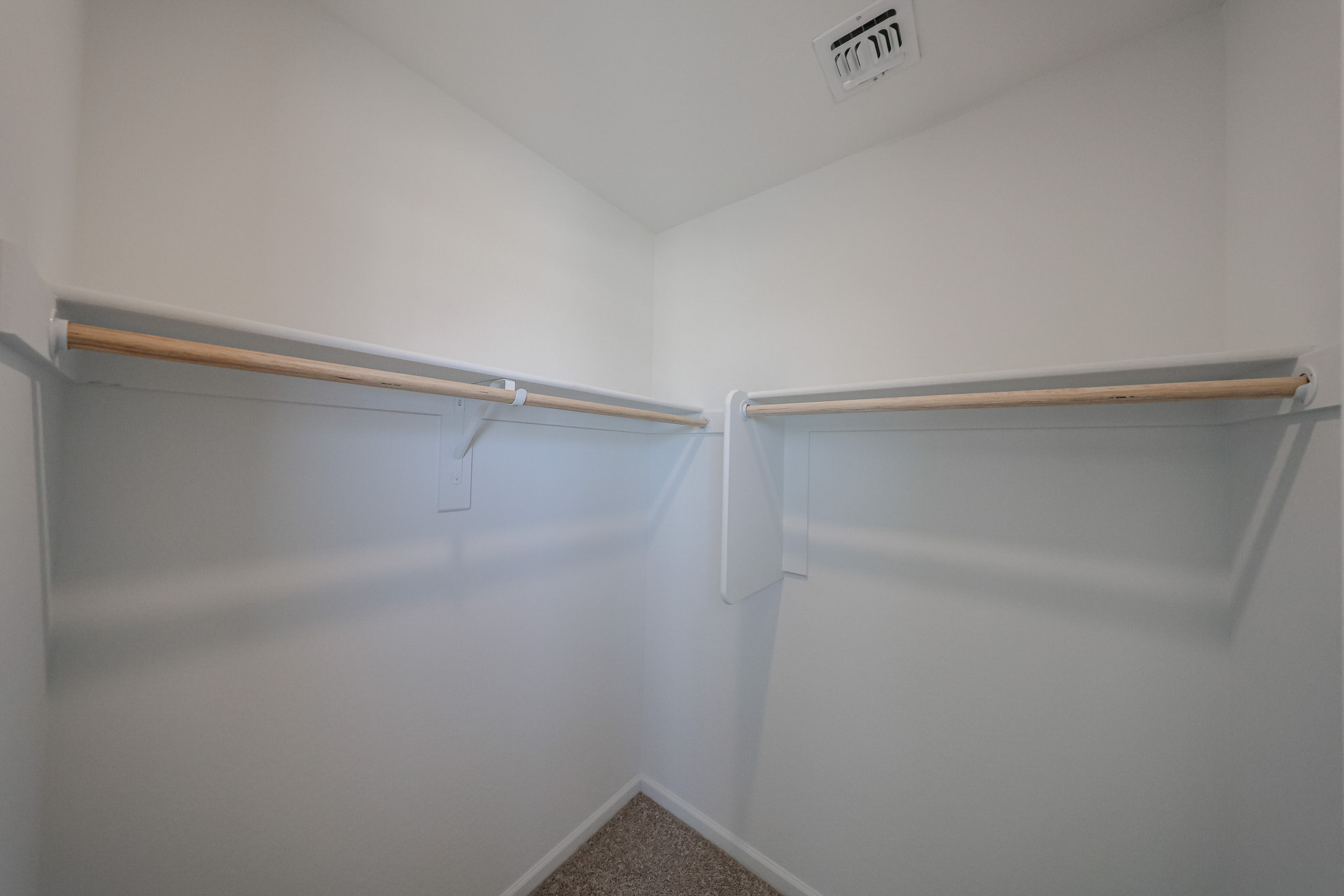 A white wall with a metal bar.