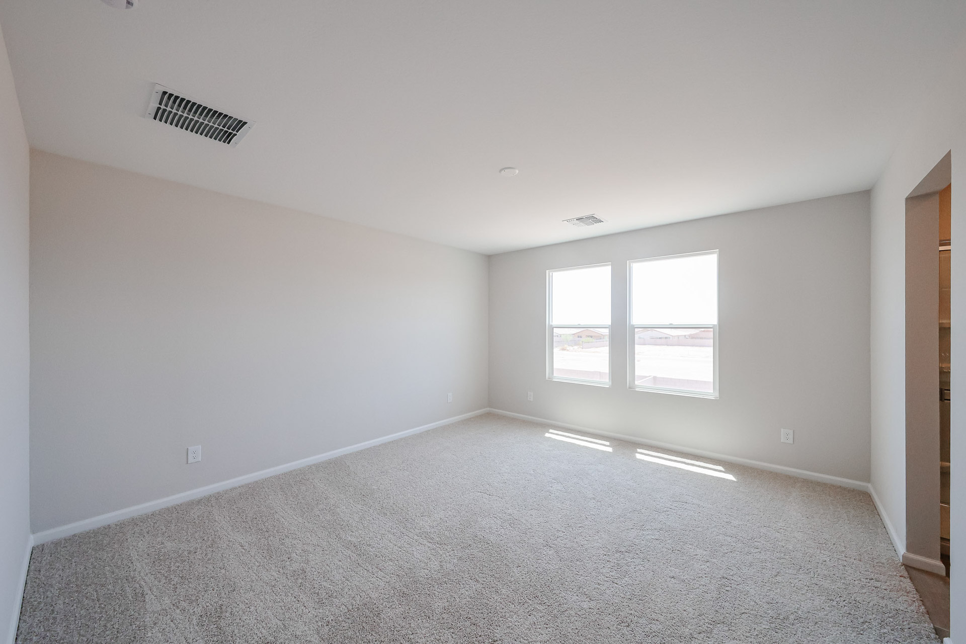 A room with a window and a carpet.