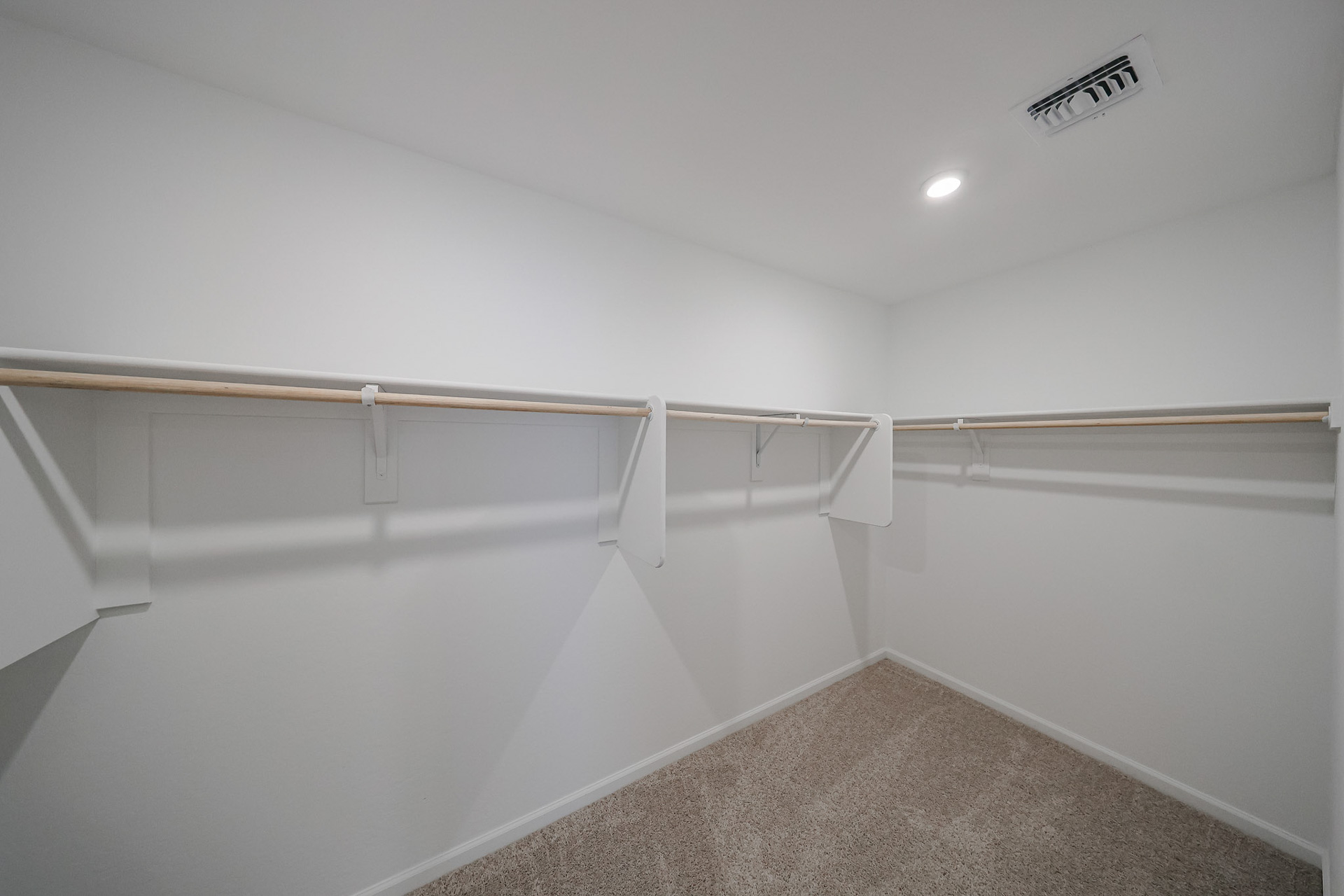 A white wall with a metal bar.