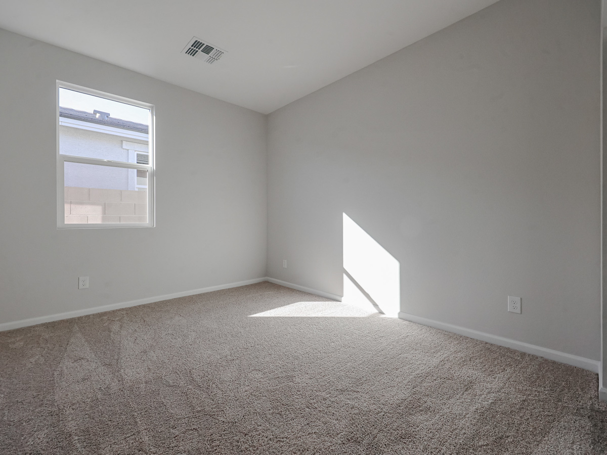 A room with a carpet and a window.
