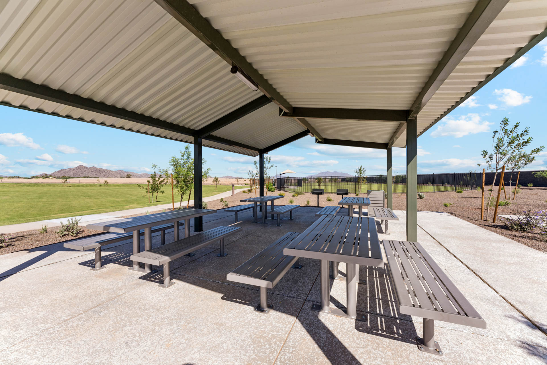 A group of picnic tables under a covered area.