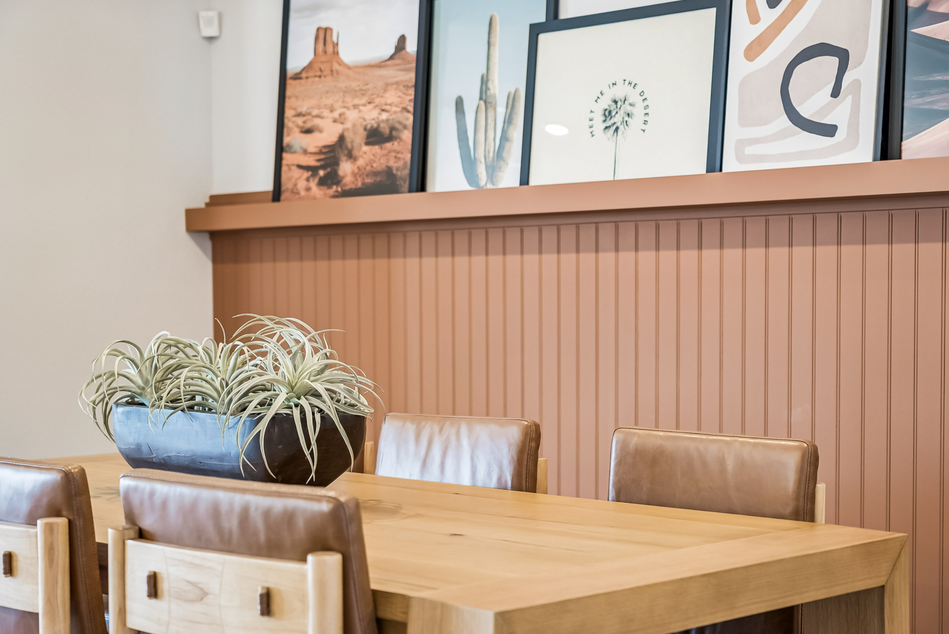 A table with chairs and plants.