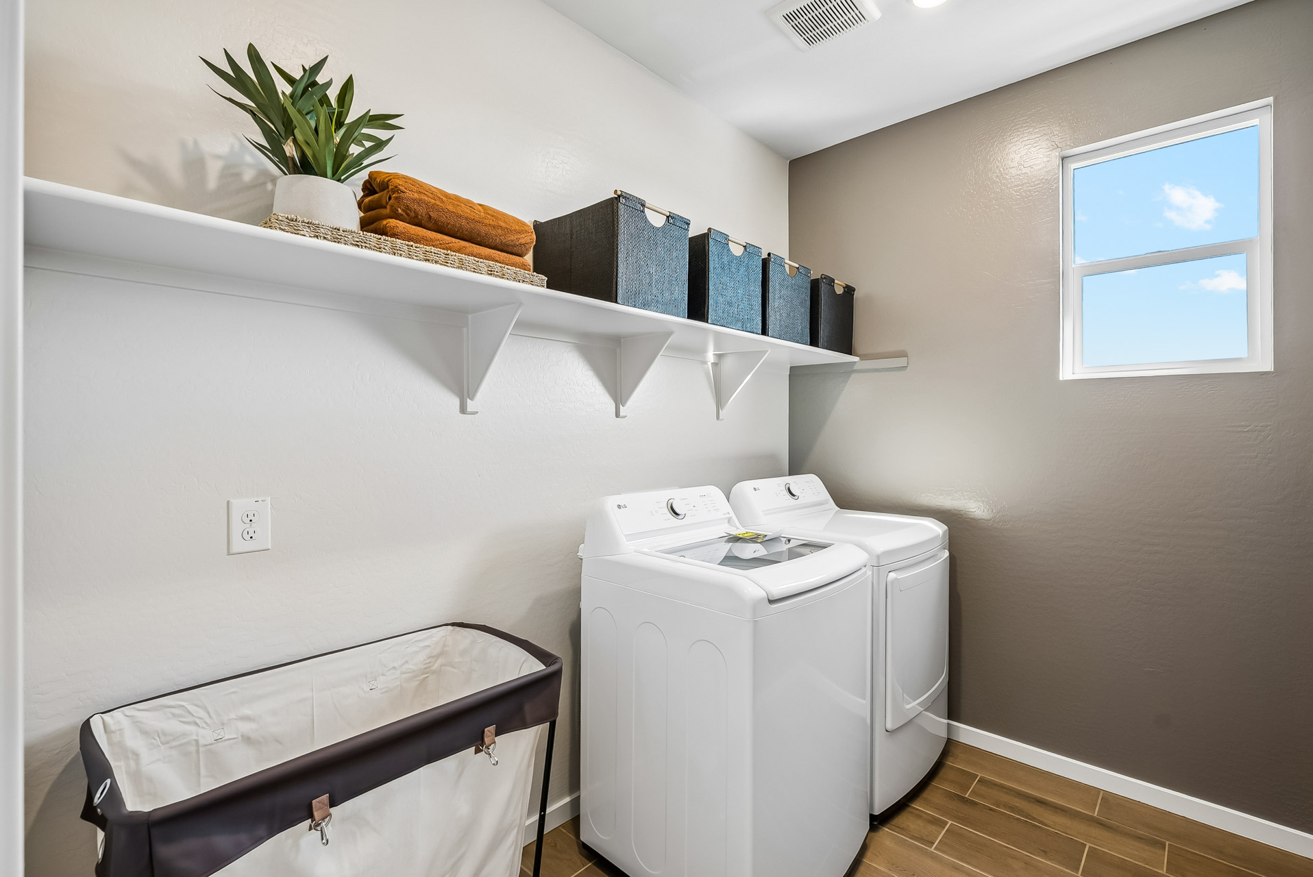 A room with a shelf and a laundry basket.