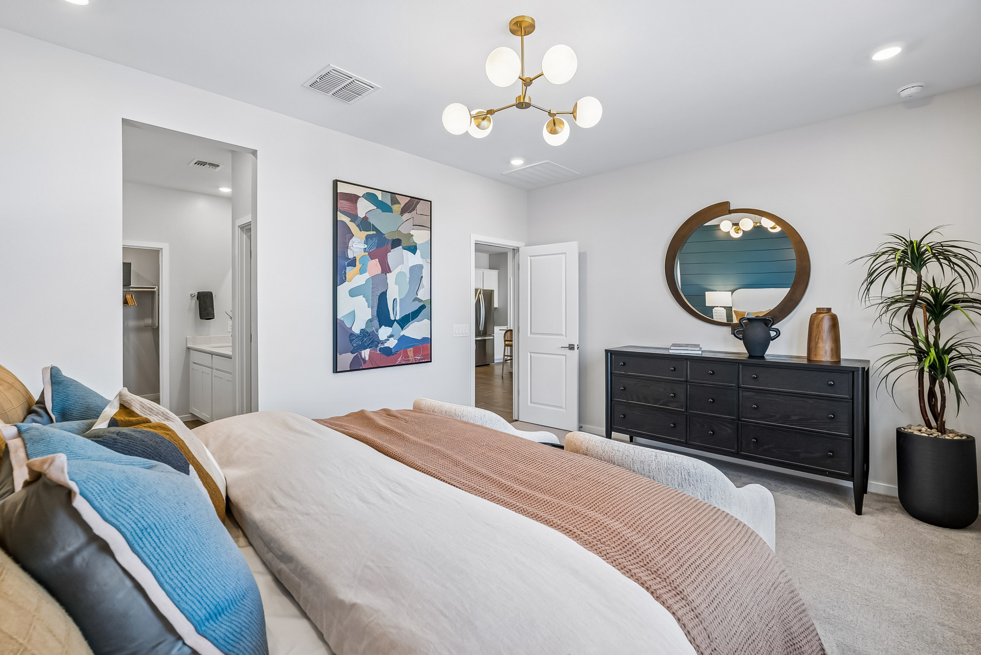 A bedroom with a bed and a mirror.