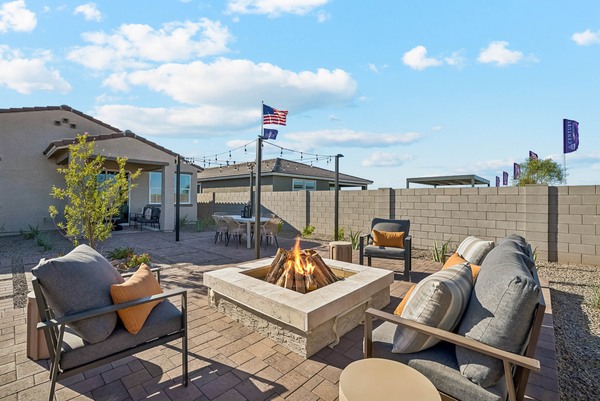 A fire pit with chairs and a fire pit in a backyard.