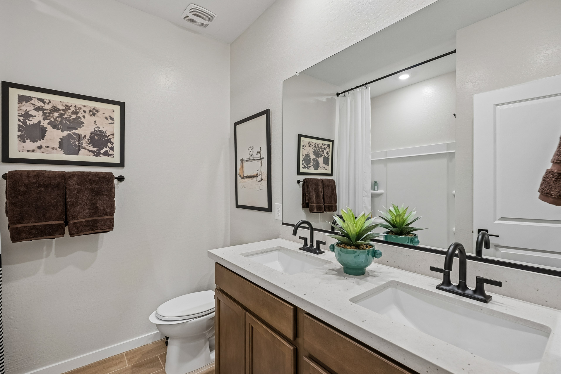 A bathroom with a sink toilet and a mirror.