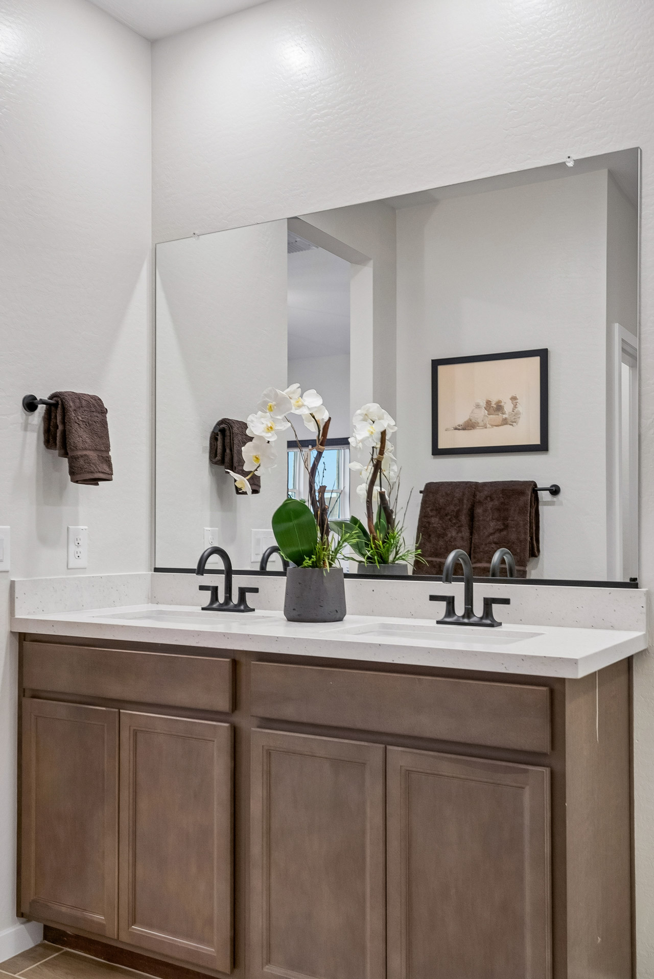 A bathroom with a mirror and flowers.