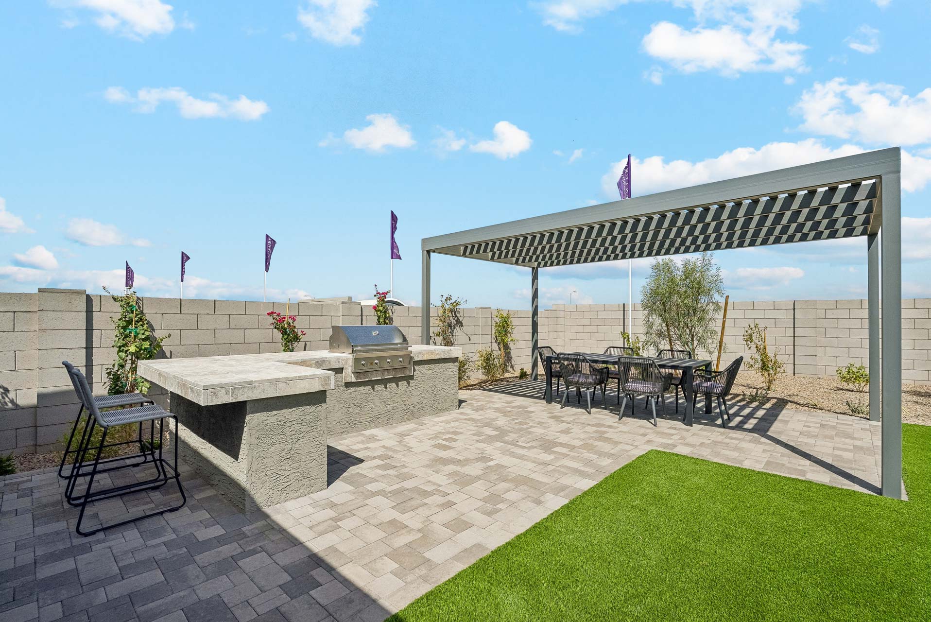 A stone patio with a glass building and a stone patio with a table and chairs and a stone.