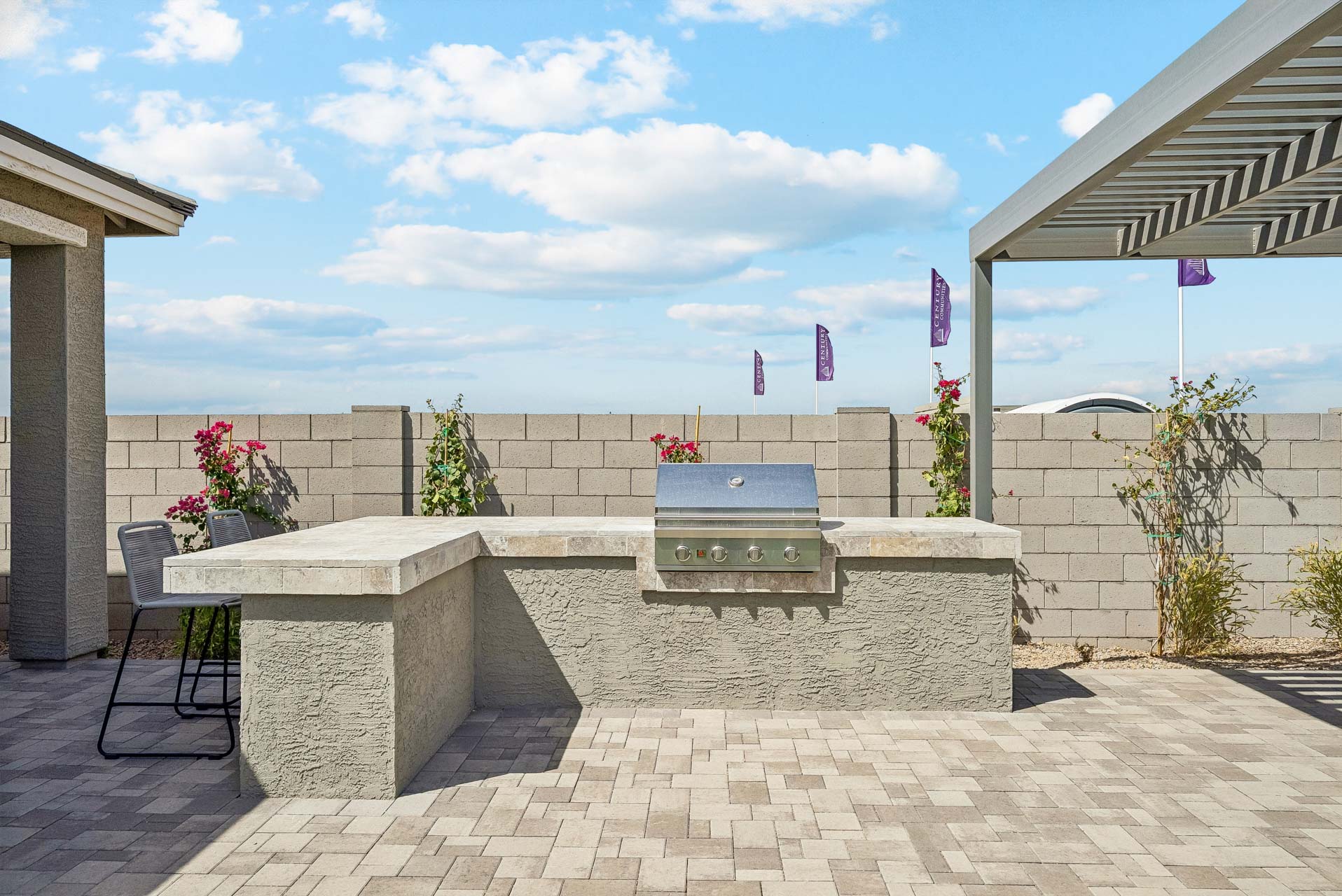 A stone patio with a bench and a table and chairs.