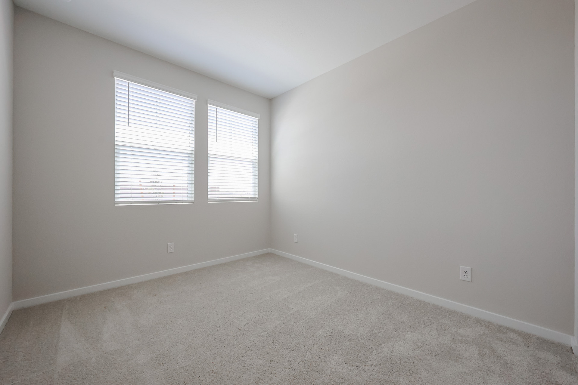 A room with a window and carpet.