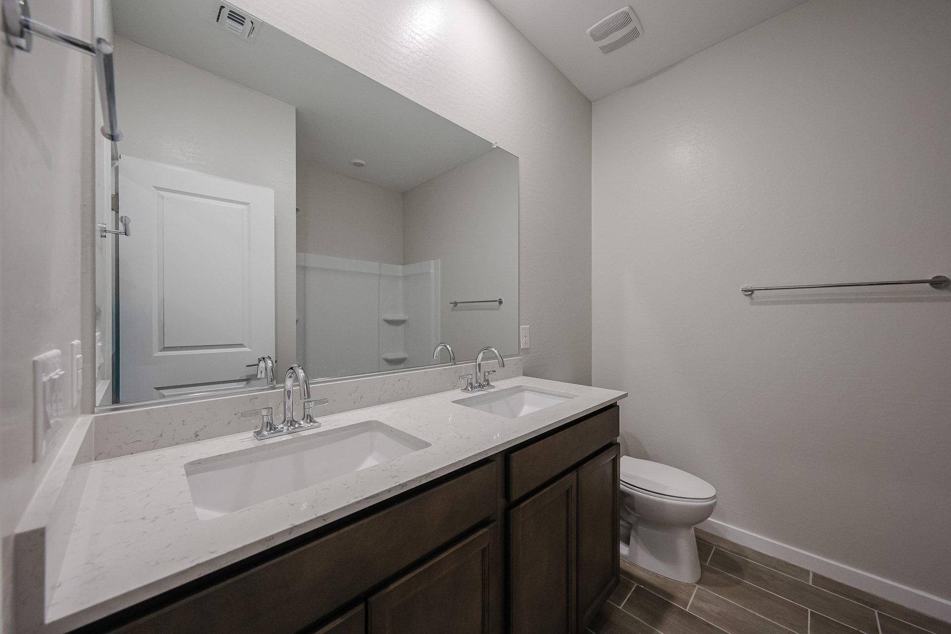 A bathroom with a sink toilet and mirror.