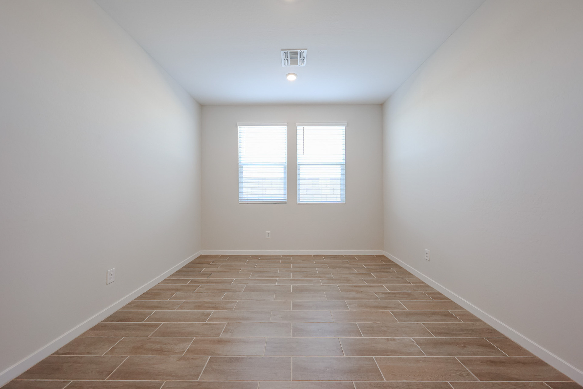 A room with a tile floor and a window.