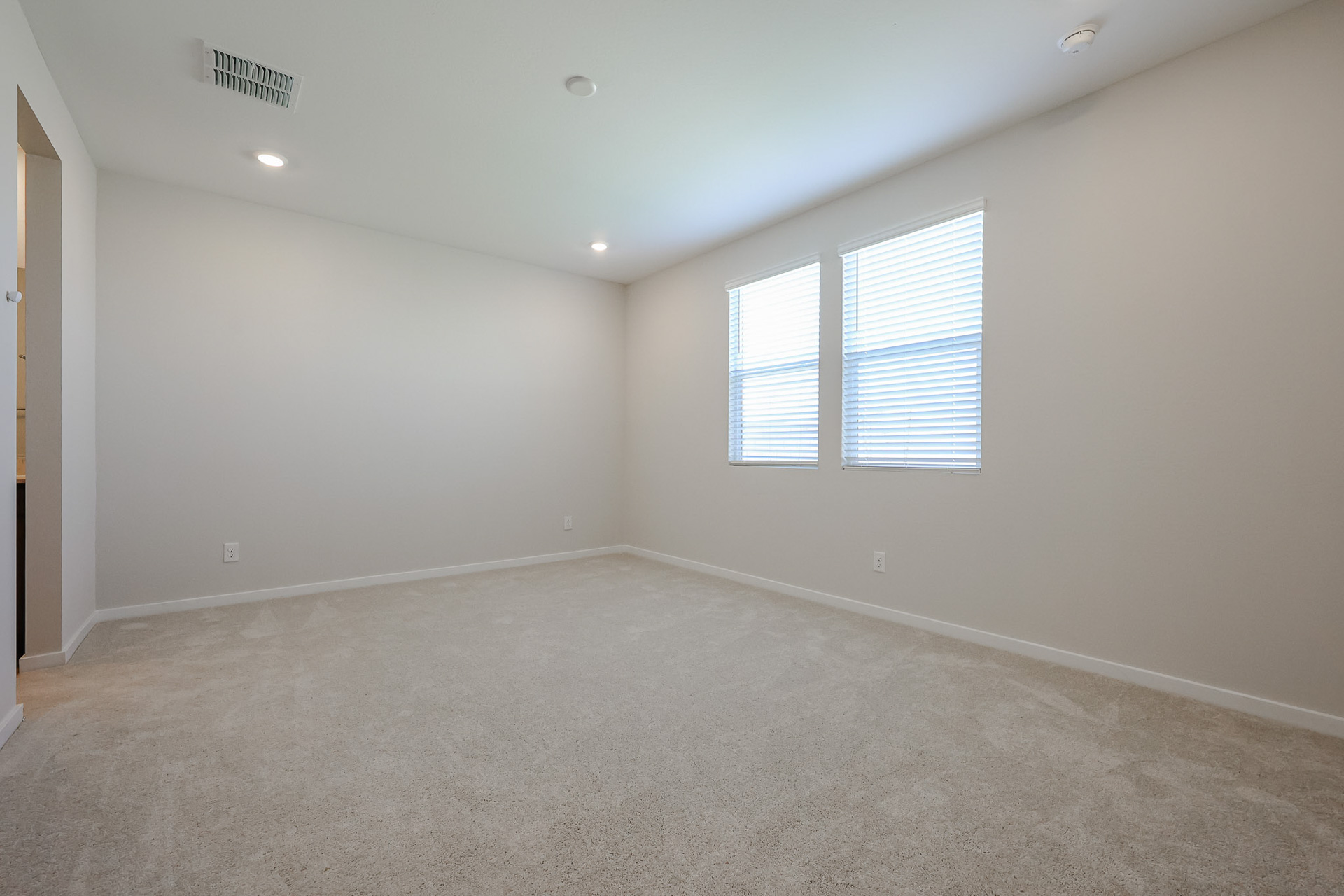 A room with a carpet and windows.