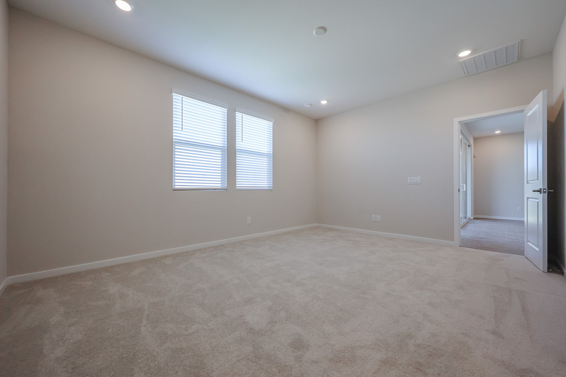 A room with a carpet and windows.